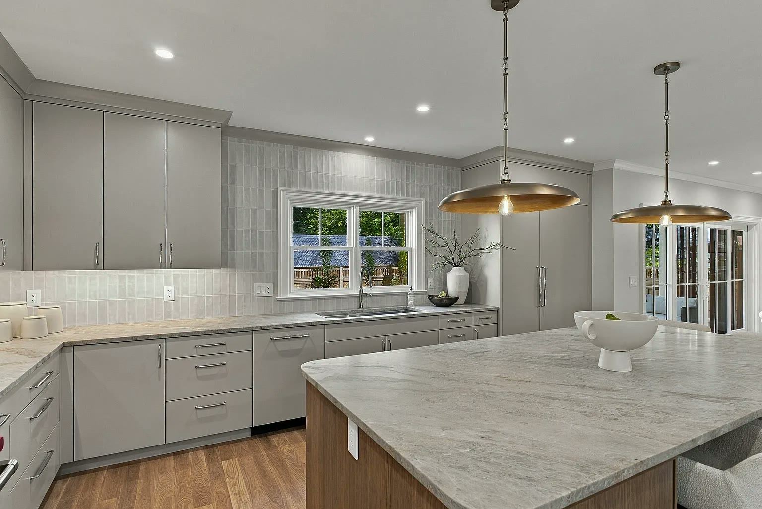 Textured stone island set against grey cabinetry in a contemporary kitchen